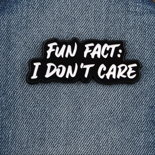 Black and white pin badge with 'Fun Fact: I Don't Care' text on a jean textured background