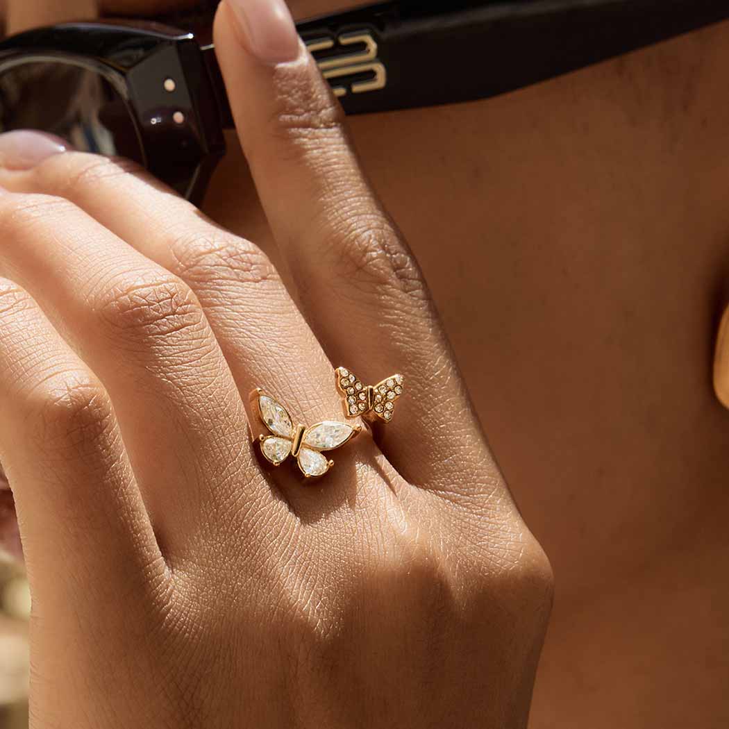 Butterfly-shaped ring on a hand with a blurred background