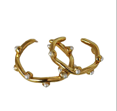 Gold pearl rings on a white surface 