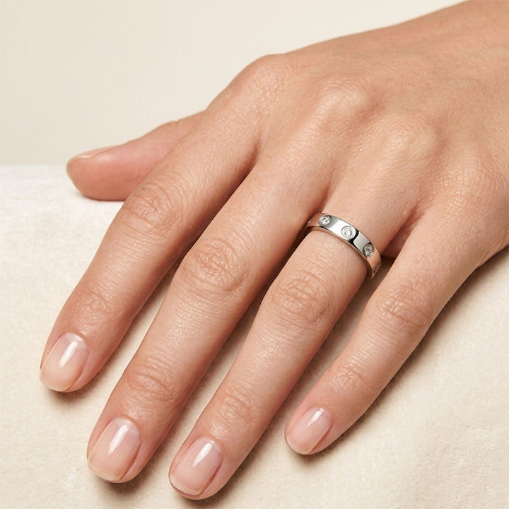 Hand  wearing ring silver with small zirconia on a beige background