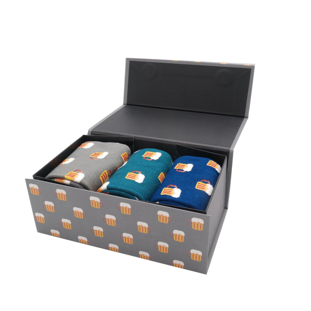 Three pairs of socks in a box with beer mug pattern on a white background