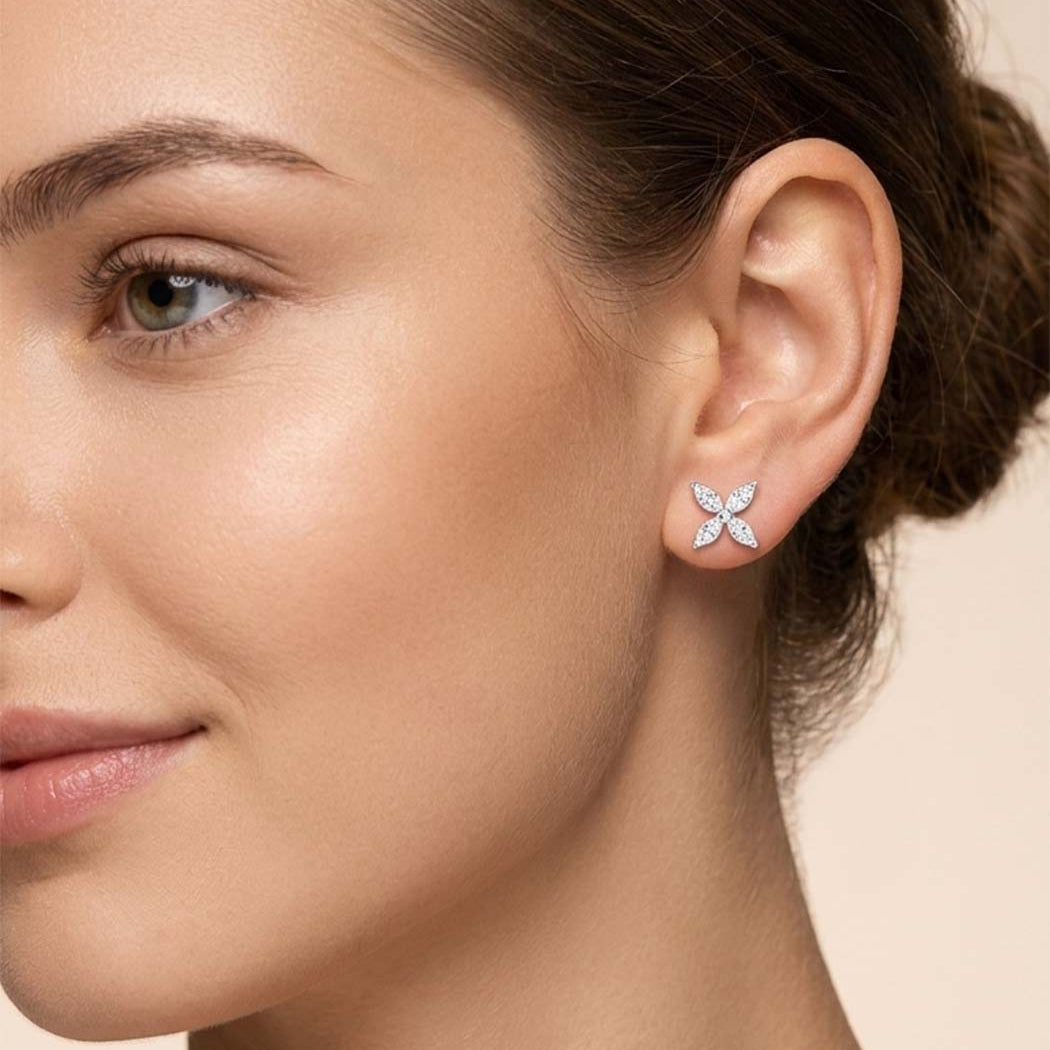 Close-up of a woman wearing a floral earring on a beige background